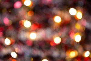 fondo de navidad con luces doradas borrosas de guirnaldas en el bokeh. oropel rojo, árbol de navidad. Año Nuevo. copie el espacio. foto