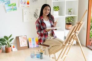 niña pintando en papel en casa, marco de madera, hobby y estudio de arte en casa. foto