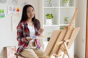 Young girl painting on paper at home, wood frame,Hobby and art study at home. photo