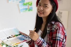 Young girl painting on paper at home, wood frame,Hobby and art study at home. photo