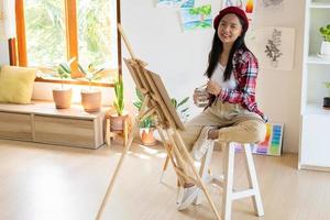 niña pintando en papel en casa, marco de madera, hobby y estudio de arte en casa. foto