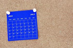 calendario azul de julio de 2023 con pin en la cartelera del boletín de corcho. foto