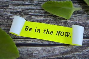 Motivational quote on yellow note with leave on wooden desk. photo