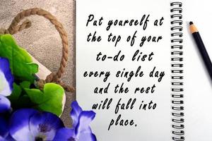 Motivational and inspirational quote on notepad with potted plant background. photo