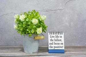 Motivational and inspirational quote on stand note with potted plant on the desk photo