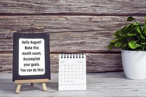 Motivational quotes on paper frame with August 2022 calendar. photo