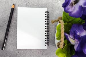 Note book with pen and potted plant on marble table. Directly above. Copy space. photo
