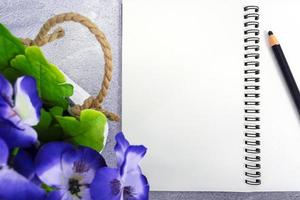 Note book with pen and potted plant on marble table. Directly above. Copy space. photo