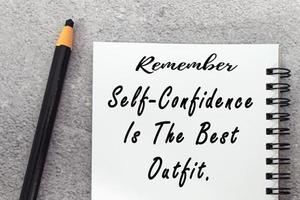 Motivational quote on notepad - Remember self confidence is the best outfit. photo