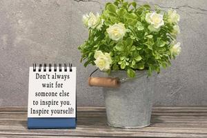 Motivational and inspirational quote on stand note with potted plant on the desk photo