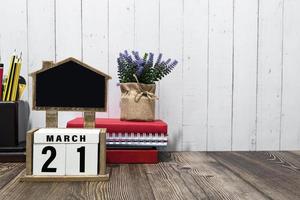 March 21 calendar date text on white wooden block with on wooden desk. photo