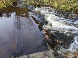 fuerte corriente en un pequeño río. rápidos en el agua foto