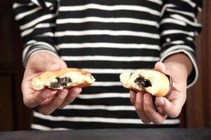 primer plano de la mano que sujeta los donuts aislado en blanco foto