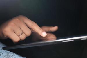 man hand using digital tablet on black background photo