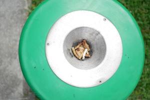 Close up burning cigarette in ashtray on table photo