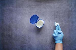 top view of hand in gloves using petroleum jelly photo