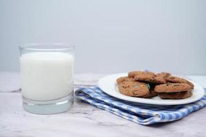 glass of milk and cookies on table photo