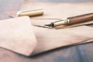 envelope , empty paper and fountain pen on table photo