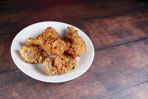 Crispy fried chicken wings on a plate top view . photo
