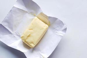 slice of a butter on a paper on table photo