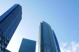 low angle view of singapore city financial buildings against blue sky photo