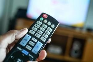 close up of man hand holding tv remote. photo