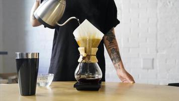 Brewing coffee in a glass coffee maker using the pour over method video