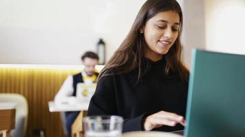 donna a caffè negozio lavori e studi su il computer portatile