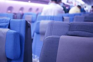 asientos de avión de pasajeros vacíos de color púrpura en la cabina foto