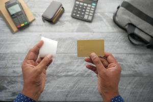 person hand holding credit card and bill paper photo