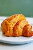 fresh baked croissant on plate with copy space photo