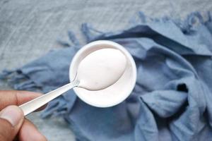 fresh yogurt on silver spoon on table photo