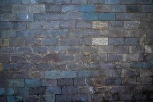 Grey stone wall with different sized stones, modern siding close up. Texture of a stone wall. Old castle stone wall texture background. Stone wall as a background or texture. Design element. photo