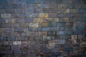 Grey stone wall with different sized stones, modern siding close up. Texture of a stone wall. Old castle stone wall texture background. Stone wall as a background or texture. Design element. photo