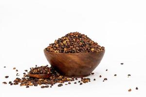 Indigofera or indigo seeds in wooden bowl isolated on white background photo