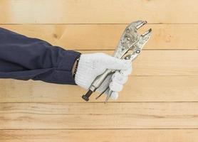 Hand in glove holding Adjustable wrench photo