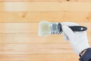 mano en guante algodón sosteniendo pinturas de pincel foto