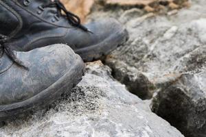 bota de cuero trekking en la roca foto