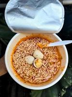 Spicy cup instant noodles with additional toppings of boiled quail eggs, very delicious and savory. photo