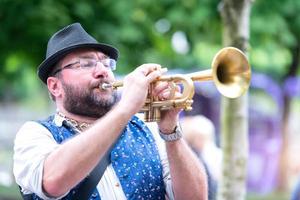un trompetista que toca en la calle por las calles de la ciudad foto