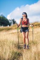 Girl practicing Nordic walking in the hills photo