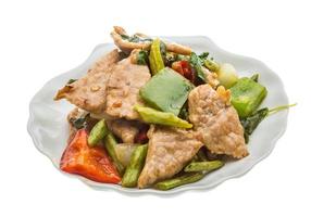 Pork with vegetables on the plate and white background photo