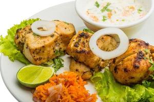 Chicken Tikka on the plate and white background photo