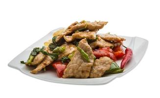 Pork with vegetables on the plate and white background photo
