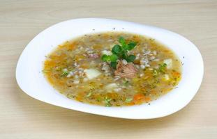 Cereal soup on the plate and wooden background photo