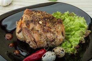 Quail grilled on the plate and wooden background photo