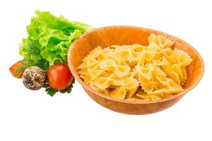 Raw pasta in a bowl on white background photo