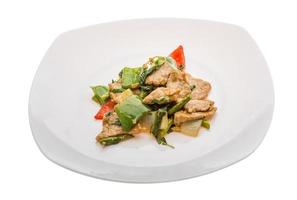 Pork with vegetables on the plate and white background photo