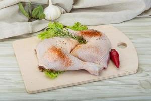 Chicken thigh on wooden background photo