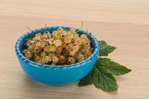 White currant in a bowl on wooden background photo